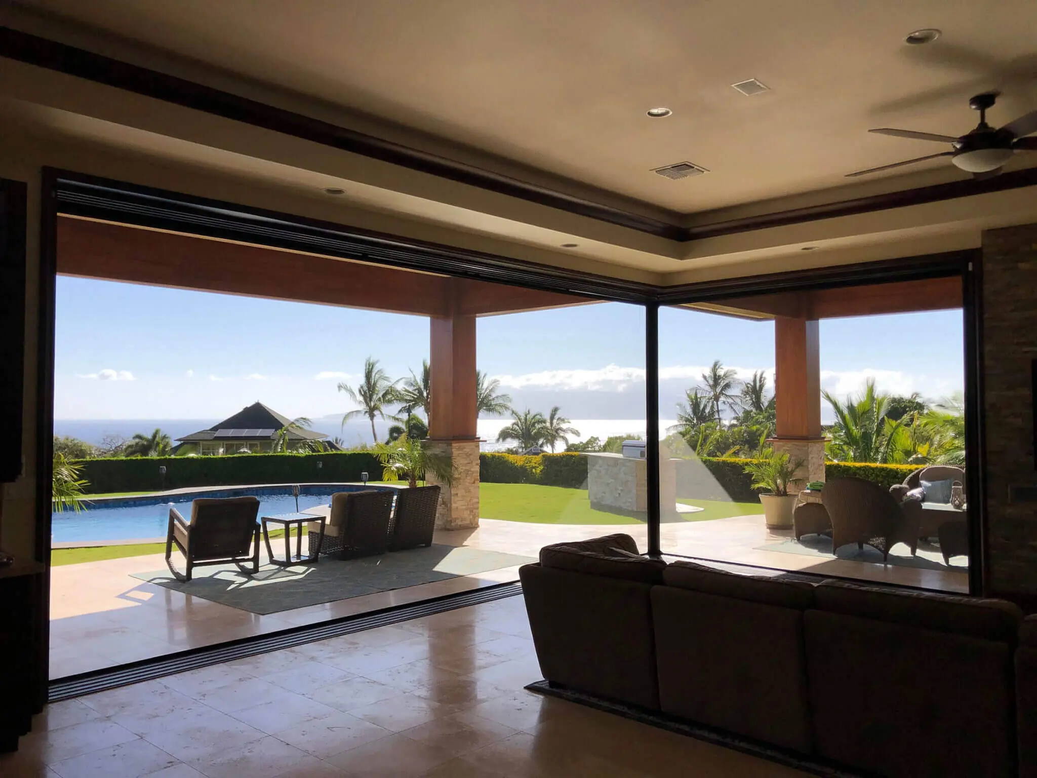 Open living space with a view of a patio, pool, and distant mountains.